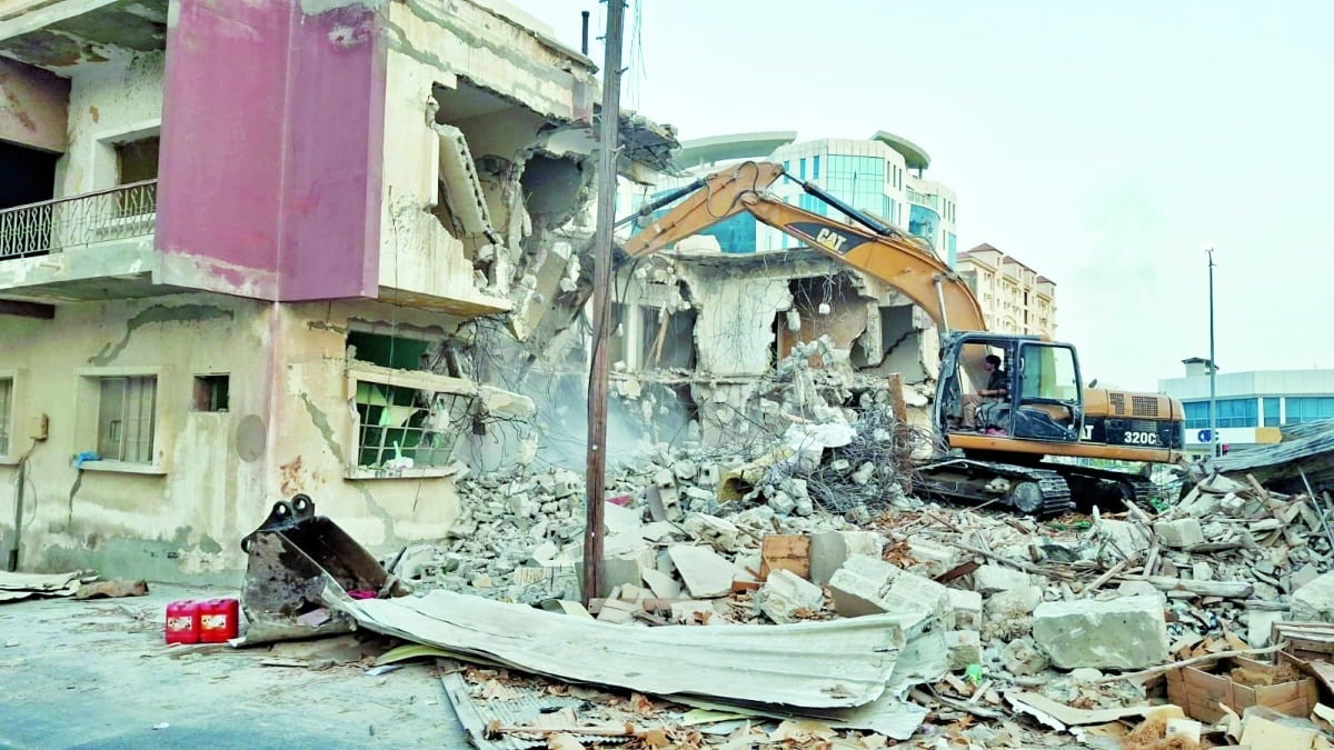 Doha Municipality demolition team overseeing the removal of a dilapidated building in New Doha